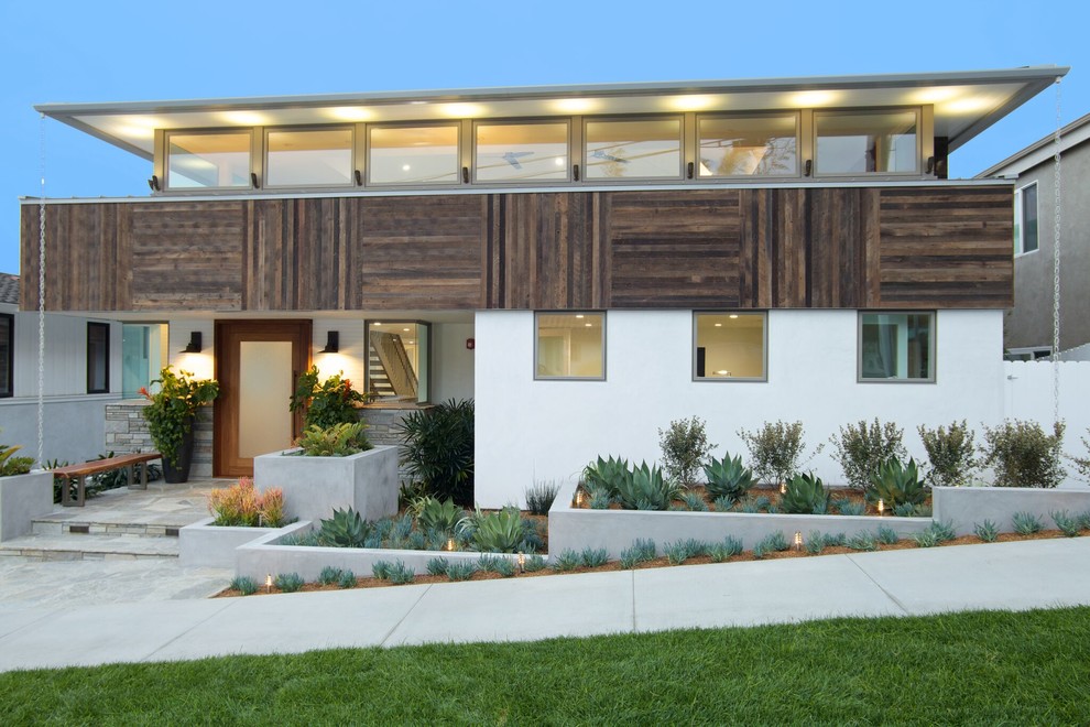 Large beach style white two-story mixed siding flat roof photo in Los Angeles