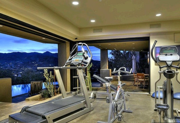 Photo of a mid-sized contemporary home weight room in Phoenix with beige walls and concrete floors.