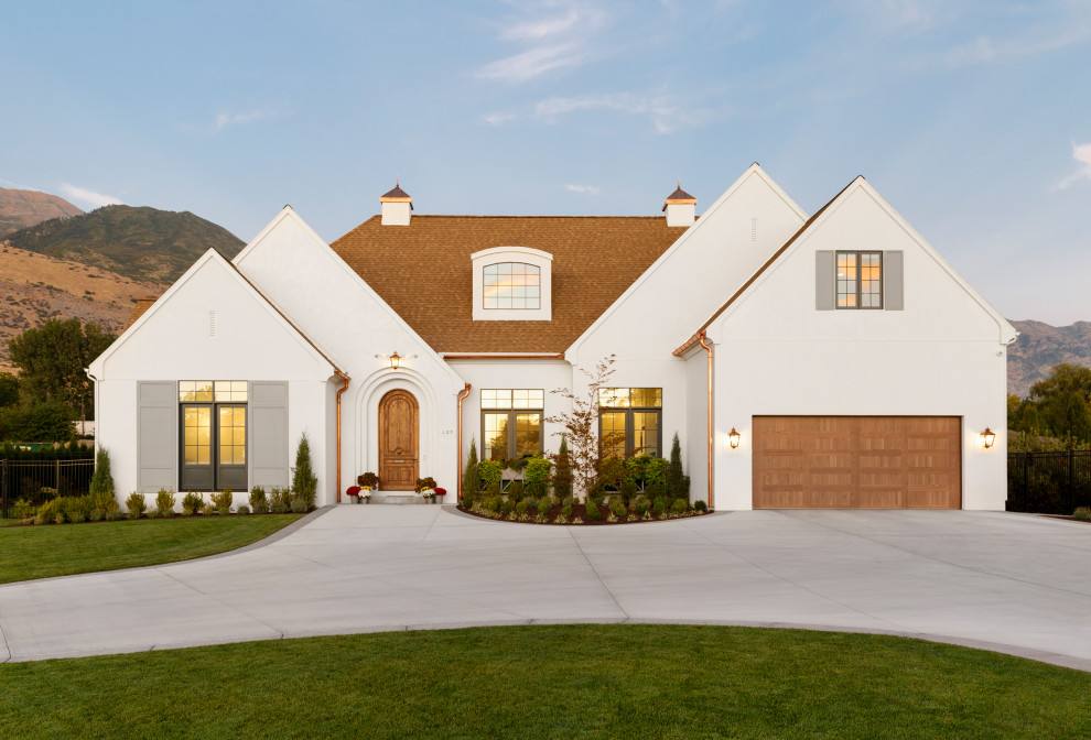 Cette photo montre une façade de maison blanche nature de plain-pied avec un toit marron.