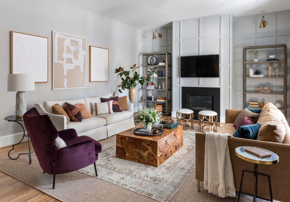 Immagine di un soggiorno classico con pareti grigie, pavimento in legno massello medio, camino classico, TV a parete, pavimento marrone e pannellatura