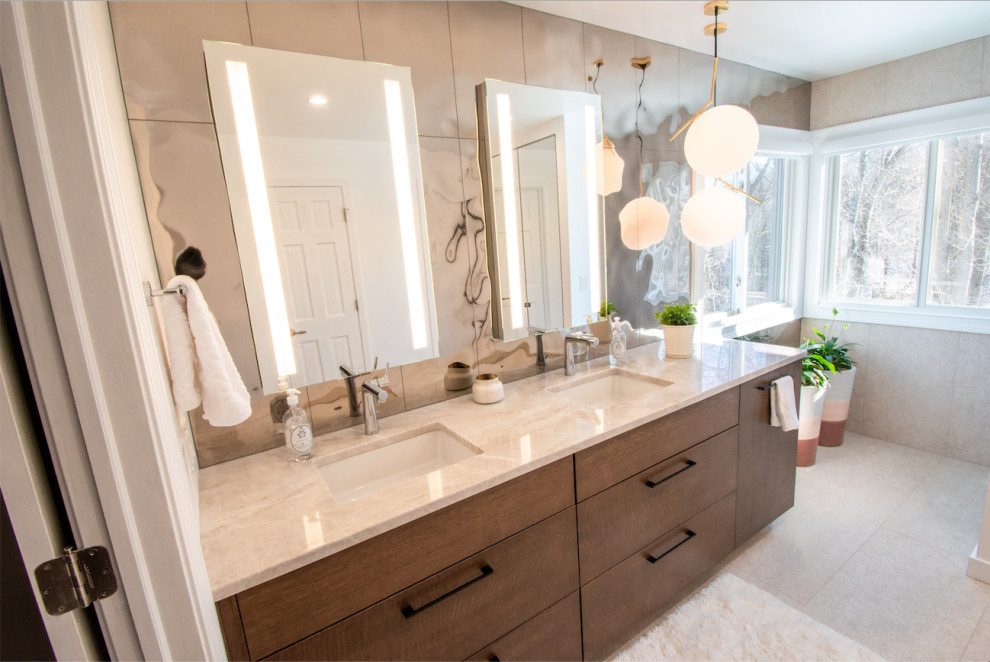 Modernes Badezimmer mit hellbraunen Holzschränken, Spiegelfliesen, Granit-Waschbecken/Waschtisch, beiger Waschtischplatte, Doppelwaschbecken und eingebautem Waschtisch in Cincinnati