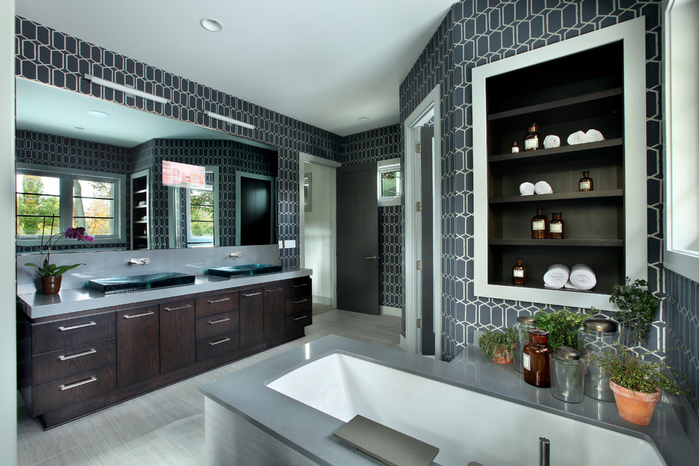This is an example of a large contemporary master bathroom in Grand Rapids with a vessel sink, flat-panel cabinets, dark wood cabinets and an undermount tub.