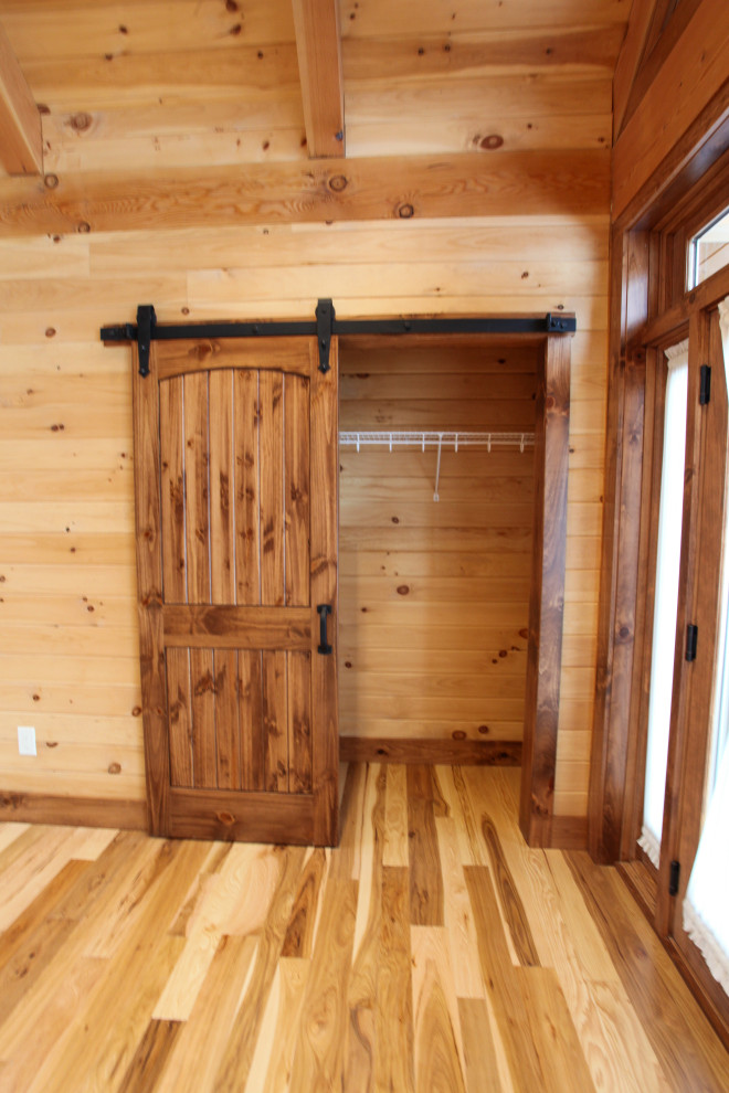 Inspiration for a rustic light wood floor, yellow floor, wood ceiling and wood wall foyer remodel with a glass front door