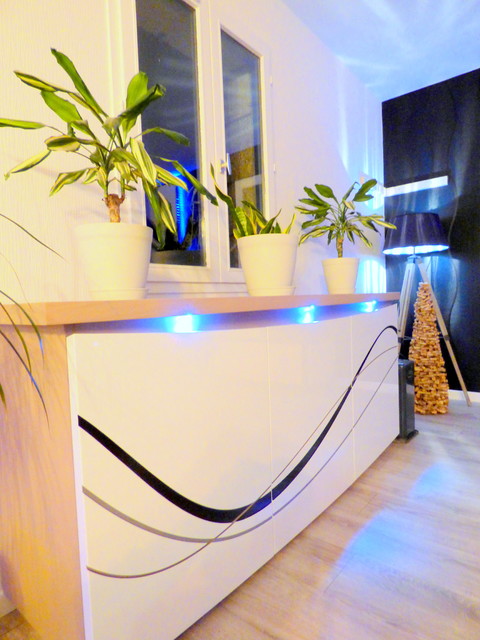 Réalisation d'un grand salon minimaliste ouvert avec un mur noir, sol en stratifié, un poêle à bois, un téléviseur indépendant et un sol gris.
