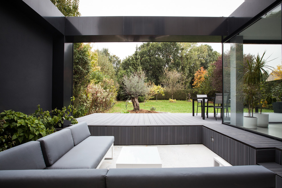 Inspiration for a contemporary side yard patio in Paris with decking.