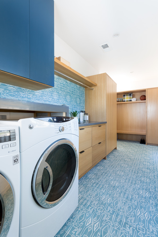 Design ideas for a large midcentury single-wall laundry room in Los Angeles with an undermount sink, flat-panel cabinets, light wood cabinets, quartz benchtops, blue walls, light hardwood floors, a side-by-side washer and dryer and grey benchtop.