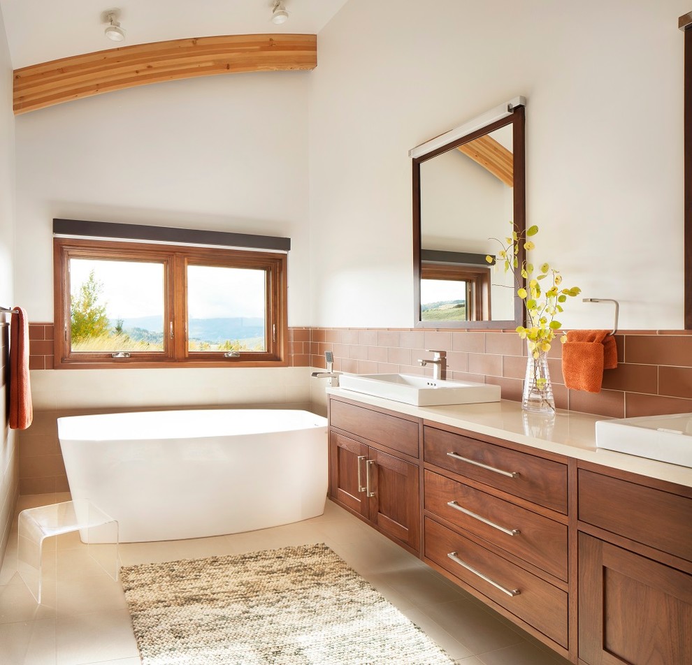 Inspiration for a rustic brown tile freestanding bathtub remodel with a vessel sink, shaker cabinets, medium tone wood cabinets and white walls