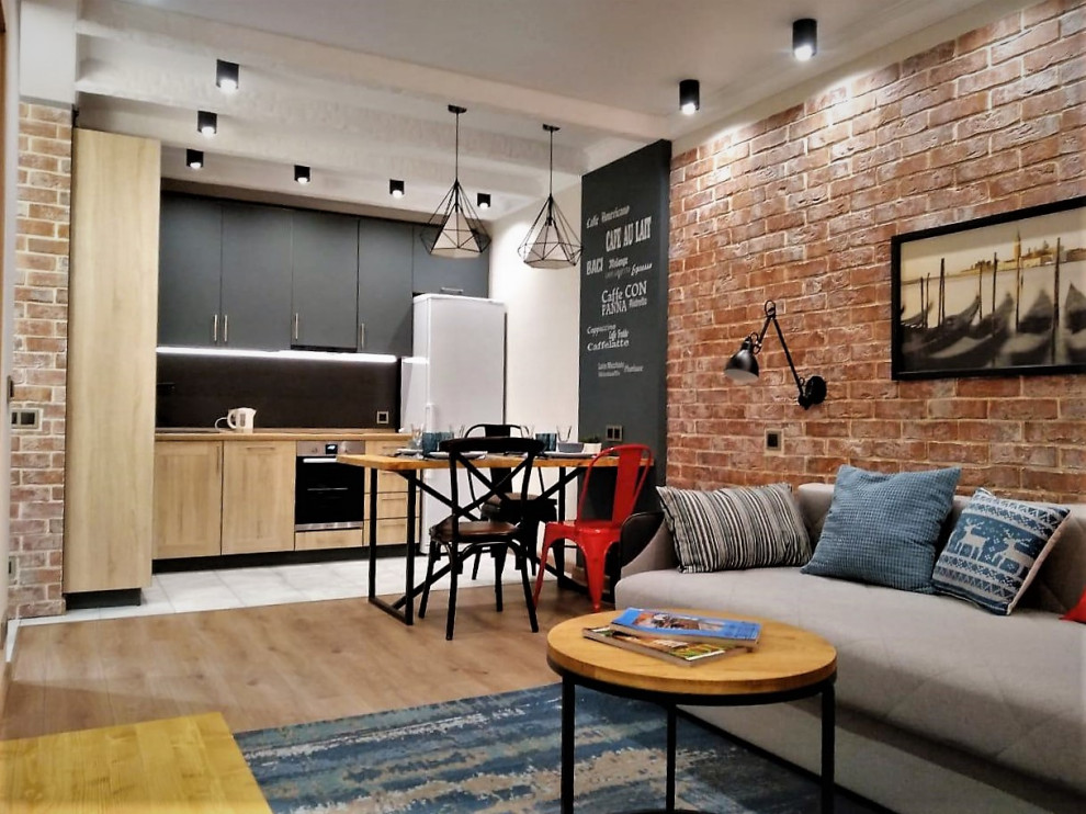 Photo of a small industrial open concept living room in Moscow with a home bar, beige walls, laminate floors, no fireplace, a wall-mounted tv, recessed and brick walls.