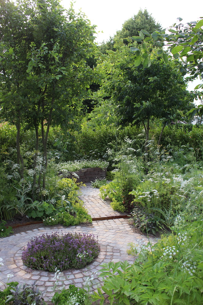 Inspiration for a small country backyard full sun xeriscape for summer in London with natural stone pavers and with pond.