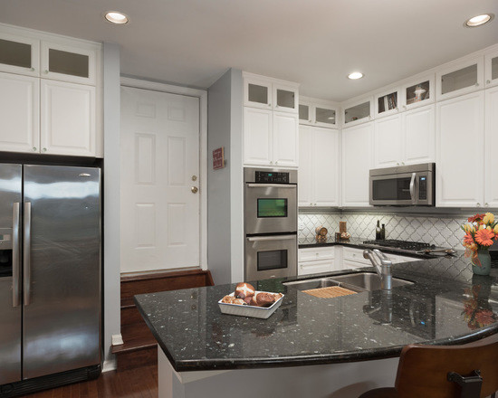 Example of a mid-sized classic u-shaped medium tone wood floor enclosed kitchen design in Chicago with an undermount sink, shaker cabinets, white cabinets, granite countertops, white backsplash, ceramic backsplash, stainless steel appliances and no island