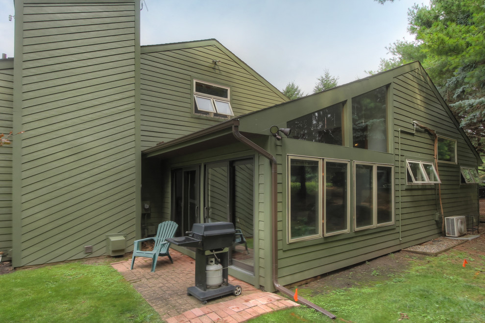 Photo of a mid-sized country green exterior in Grand Rapids with concrete fiberboard siding.