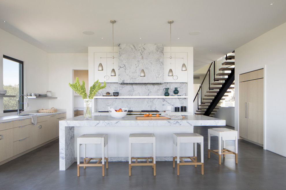Moderne Küche mit Unterbauwaschbecken, flächenbündigen Schrankfronten, hellen Holzschränken, Betonboden, Kücheninsel und grauem Boden in San Francisco