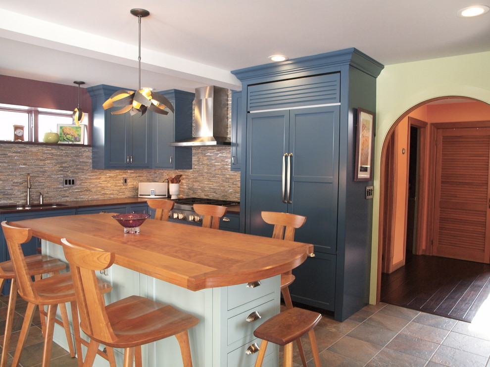Photo of a large transitional u-shaped separate kitchen in Burlington with shaker cabinets, blue cabinets, slate floors, with island, beige floor, a double-bowl sink, granite benchtops, multi-coloured splashback, matchstick tile splashback, panelled appliances and brown benchtop.