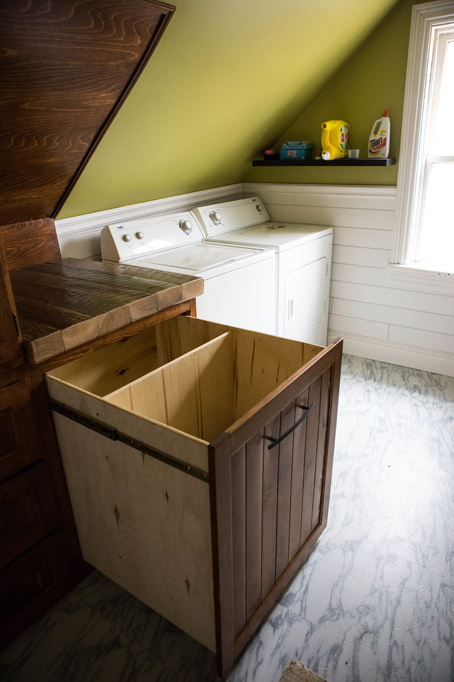 Inspiration for a mid-sized country single-wall utility room in Toronto with beaded inset cabinets, dark wood cabinets, wood benchtops, green walls, vinyl floors, a side-by-side washer and dryer, white floor and brown benchtop.
