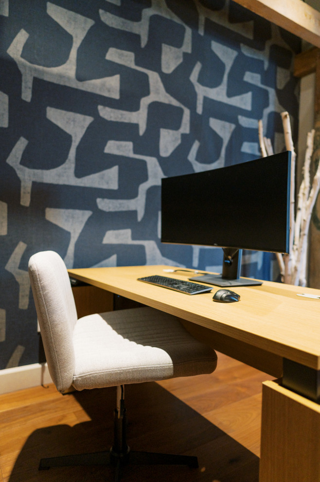 Immagine di un atelier moderno di medie dimensioni con pareti multicolore, scrivania autoportante, parquet chiaro, pavimento beige, travi a vista e carta da parati