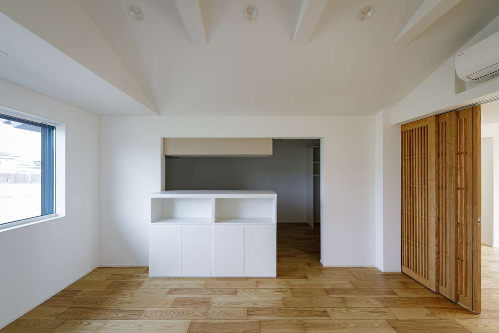 Foto di un'ampia sala da pranzo moderna chiusa con pareti bianche, pavimento in legno verniciato, pavimento beige e carta da parati