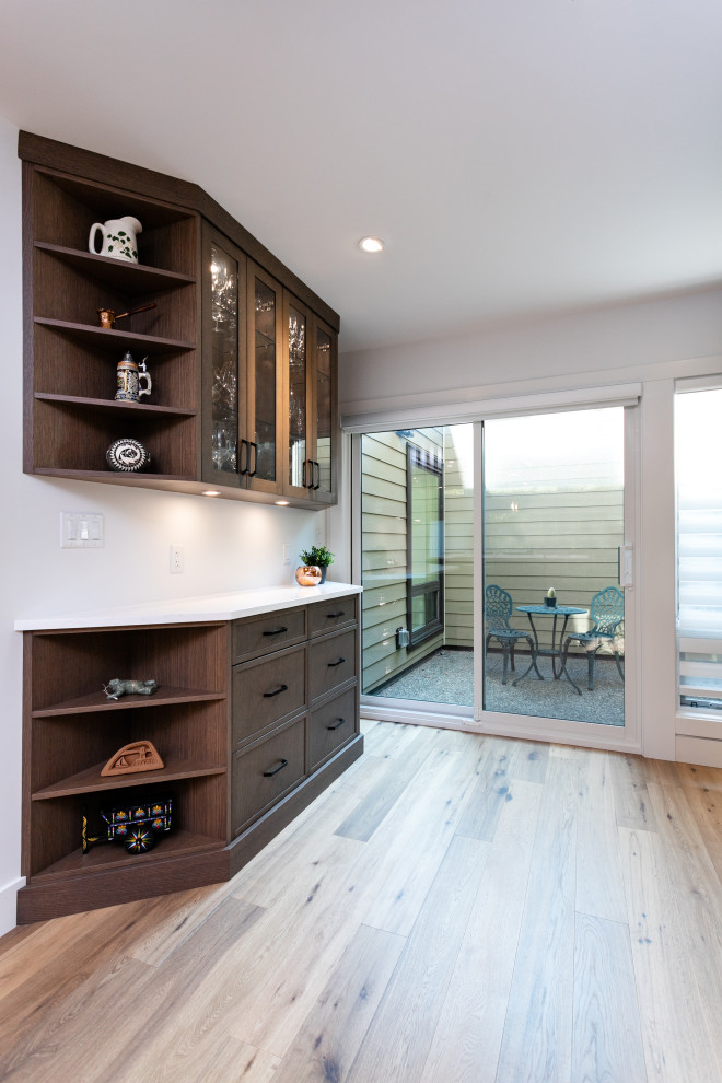 Example of a mid-sized transitional u-shaped medium tone wood floor and brown floor open concept kitchen design in Vancouver with an undermount sink, shaker cabinets, dark wood cabinets, quartz countertops, white backsplash, porcelain backsplash, stainless steel appliances, a peninsula and white countertops