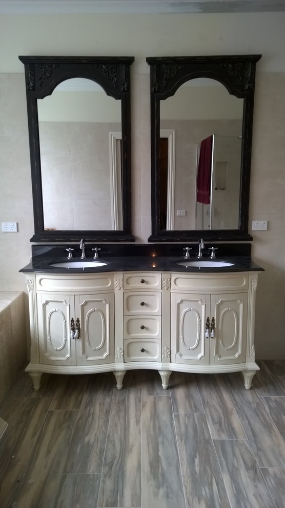 Mid-sized mediterranean master bathroom in Melbourne with an undermount sink, furniture-like cabinets, beige cabinets, granite benchtops, a hot tub, a corner shower, multi-coloured tile, porcelain tile, multi-coloured walls and porcelain floors.