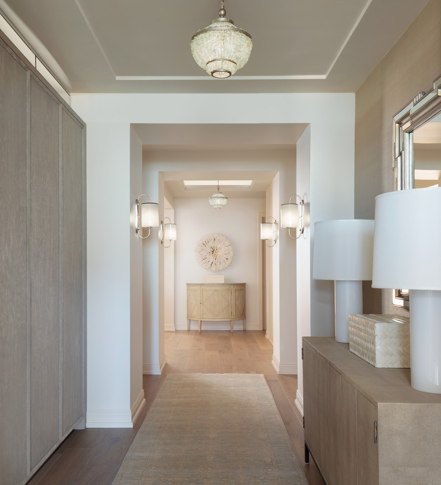 Inspiration for a large beach style hallway in Tampa with white walls and light hardwood floors.