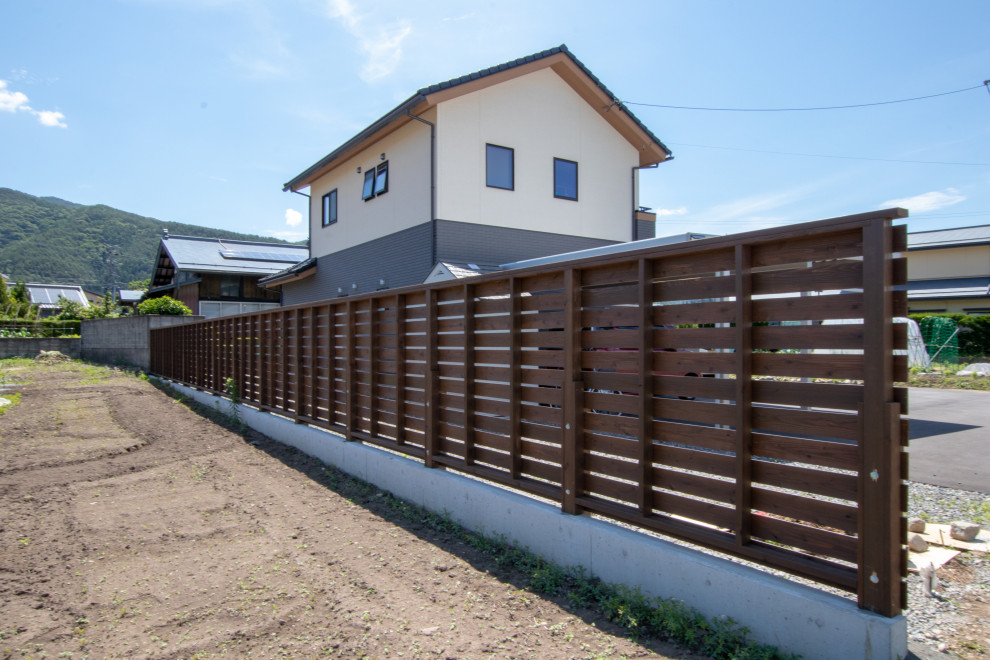 This is an example of a modern garden in Other with with privacy feature and a wood fence.