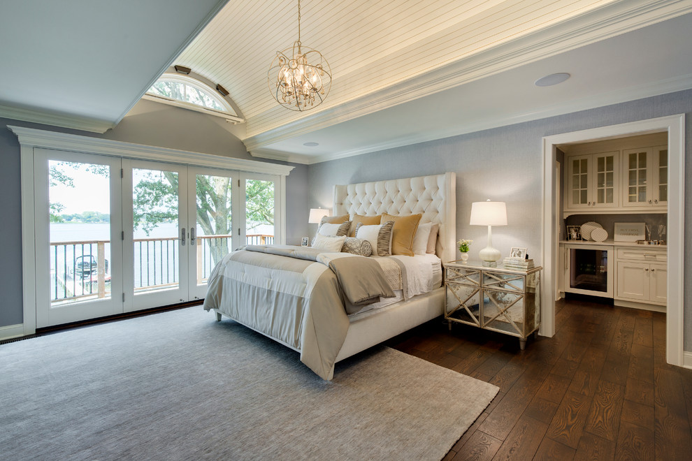 This is an example of a large beach style master bedroom in Minneapolis with grey walls, dark hardwood floors, no fireplace and brown floor.