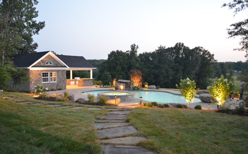 Large transitional backyard custom-shaped natural pool in DC Metro with concrete pavers.