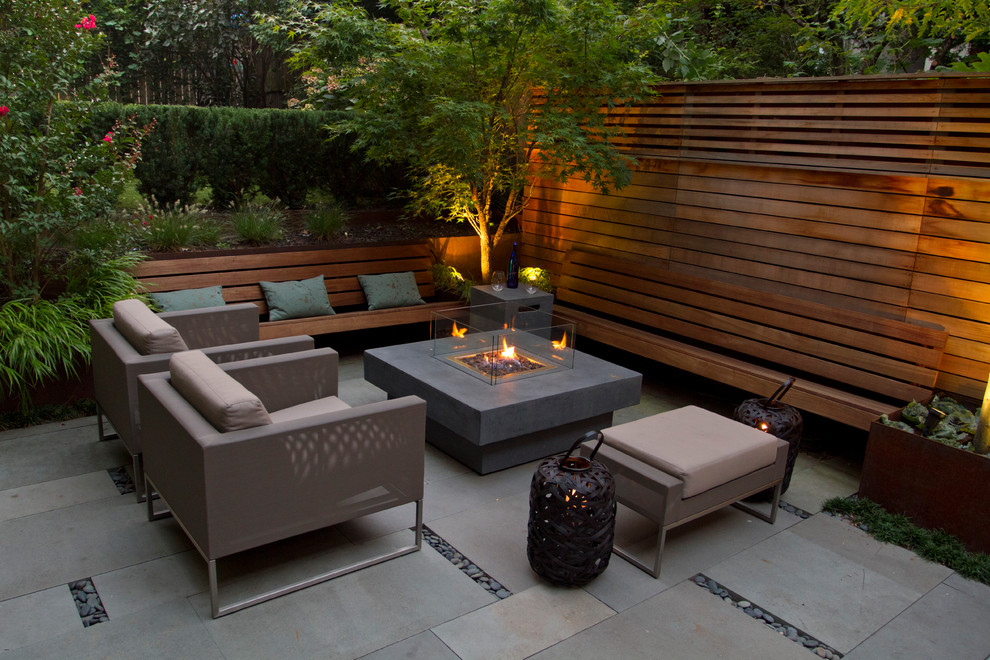 Photo of a small modern backyard patio in Toronto with a fire feature and natural stone pavers.