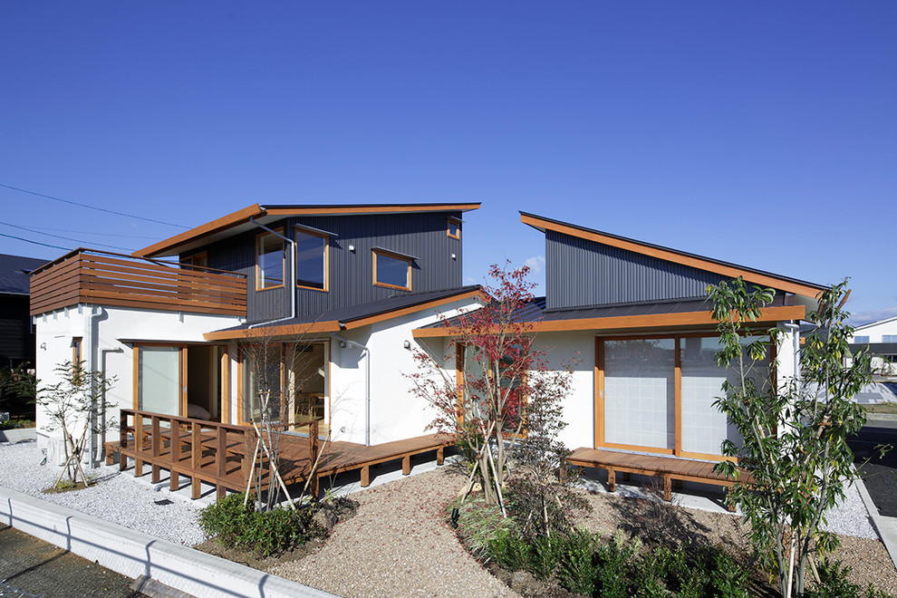 This is an example of an asian two-storey black exterior in Other with wood siding and a shed roof.