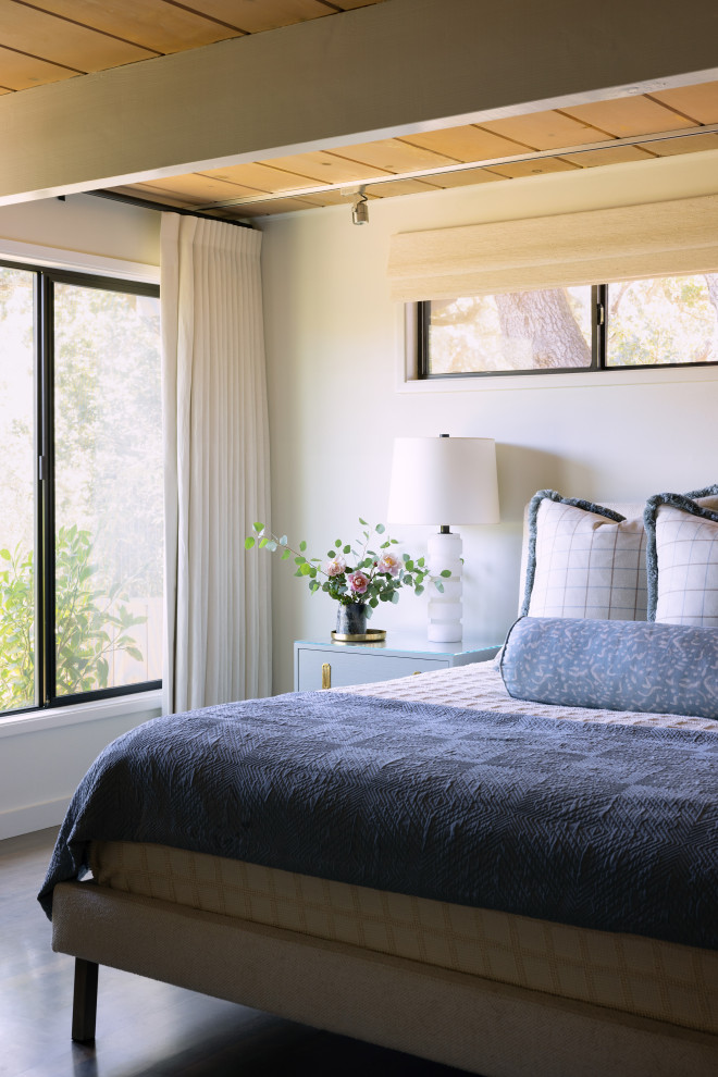 Modelo de dormitorio principal vintage de tamaño medio sin chimenea con paredes blancas, suelo de madera en tonos medios, suelo marrón y vigas vistas