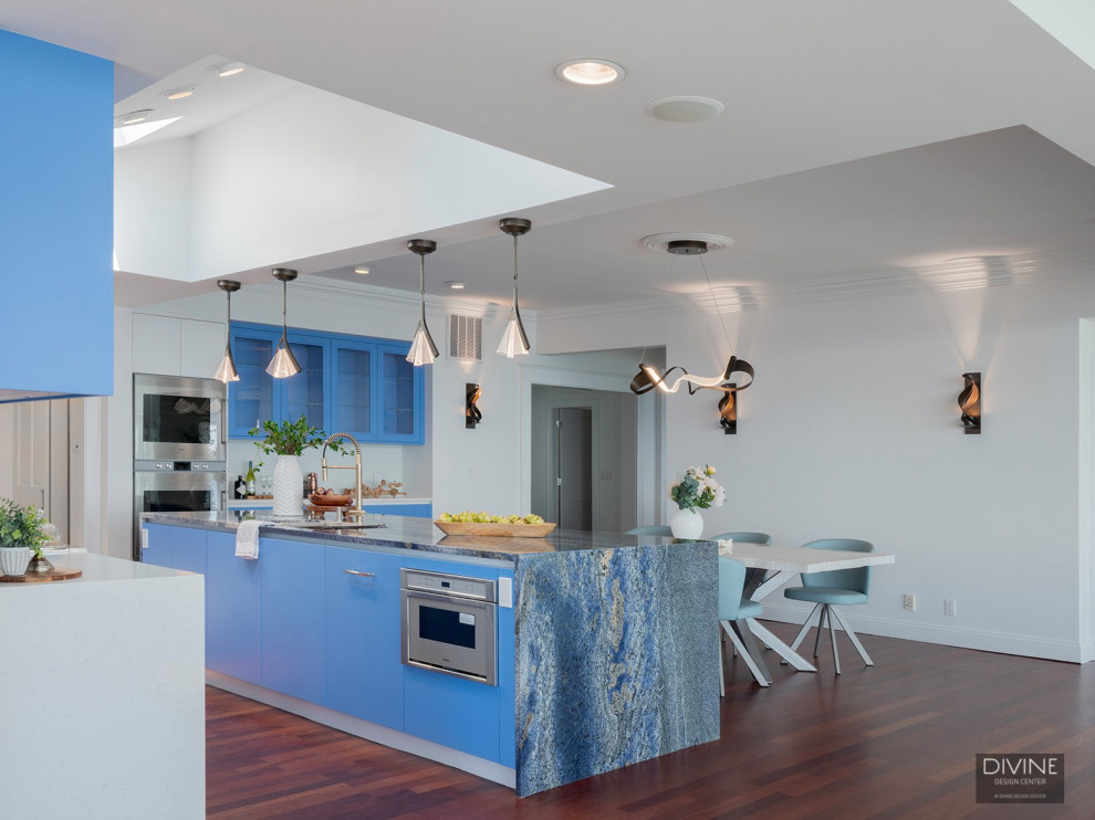 Exemple d'une très grande cuisine ouverte chic en L avec un placard à porte vitrée, des portes de placard bleues, plan de travail en marbre, un électroménager en acier inoxydable, un sol en bois brun, îlot, un sol marron et un plan de travail bleu.