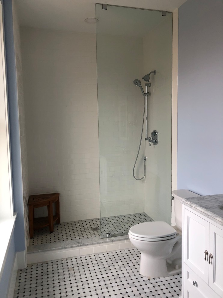This is an example of a mid-sized contemporary master bathroom in Philadelphia with shaker cabinets, white cabinets, an open shower, a two-piece toilet, white tile, subway tile, blue walls, marble floors, an undermount sink, marble benchtops, grey floor, an open shower and grey benchtops.