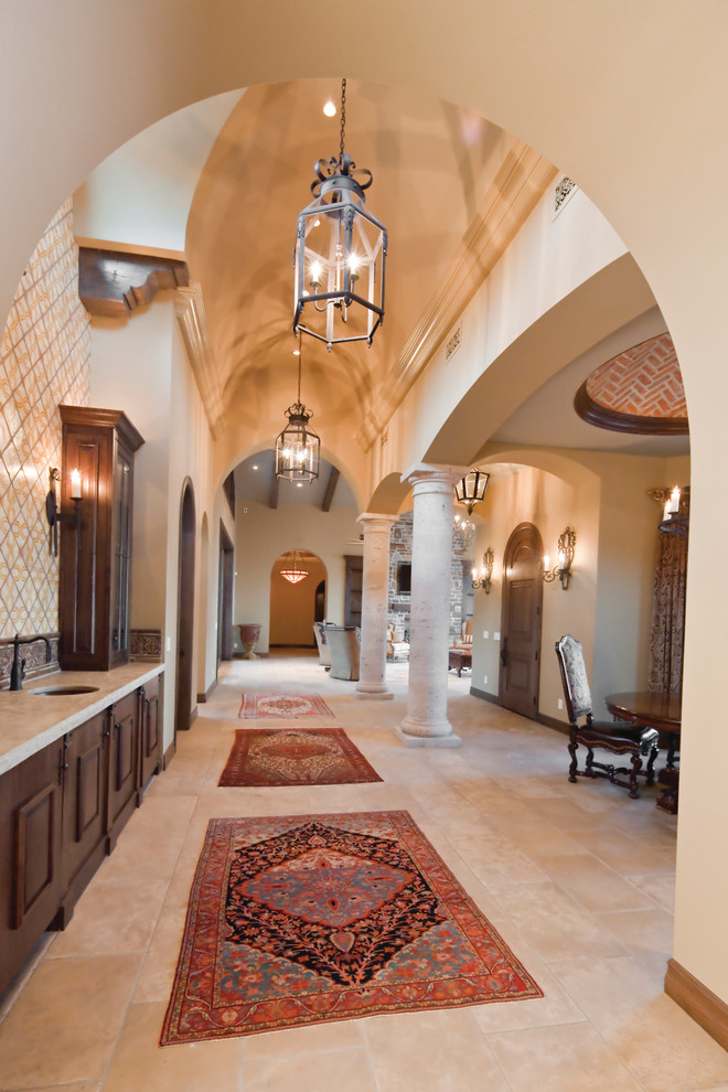 This is an example of a large mediterranean hallway in Phoenix with beige walls and travertine floors.