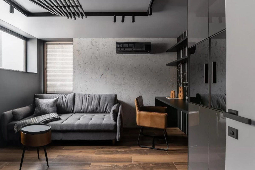 Modelo de despacho contemporáneo grande con paredes grises, suelo de baldosas de porcelana, escritorio empotrado, suelo marrón y panelado