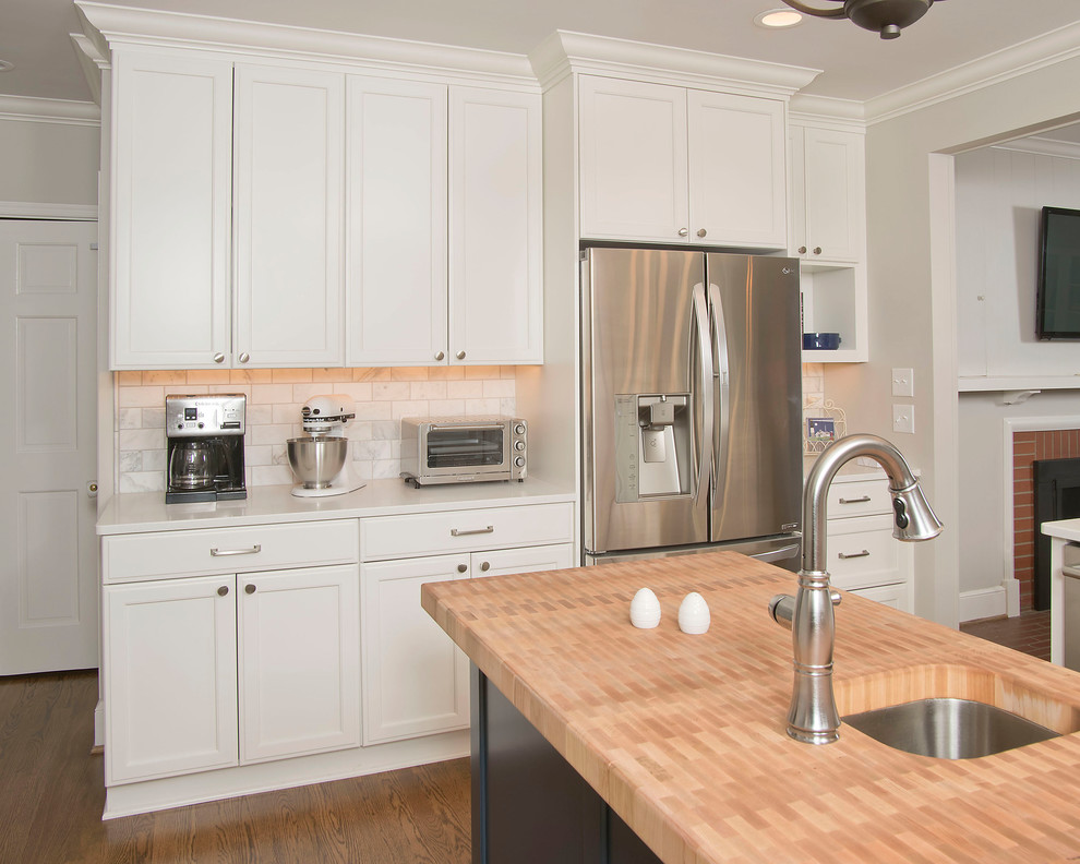 Inspiration for a mid-sized transitional u-shaped medium tone wood floor and brown floor eat-in kitchen remodel with an undermount sink, recessed-panel cabinets, white cabinets, quartz countertops, gray backsplash, marble backsplash, stainless steel appliances and an island