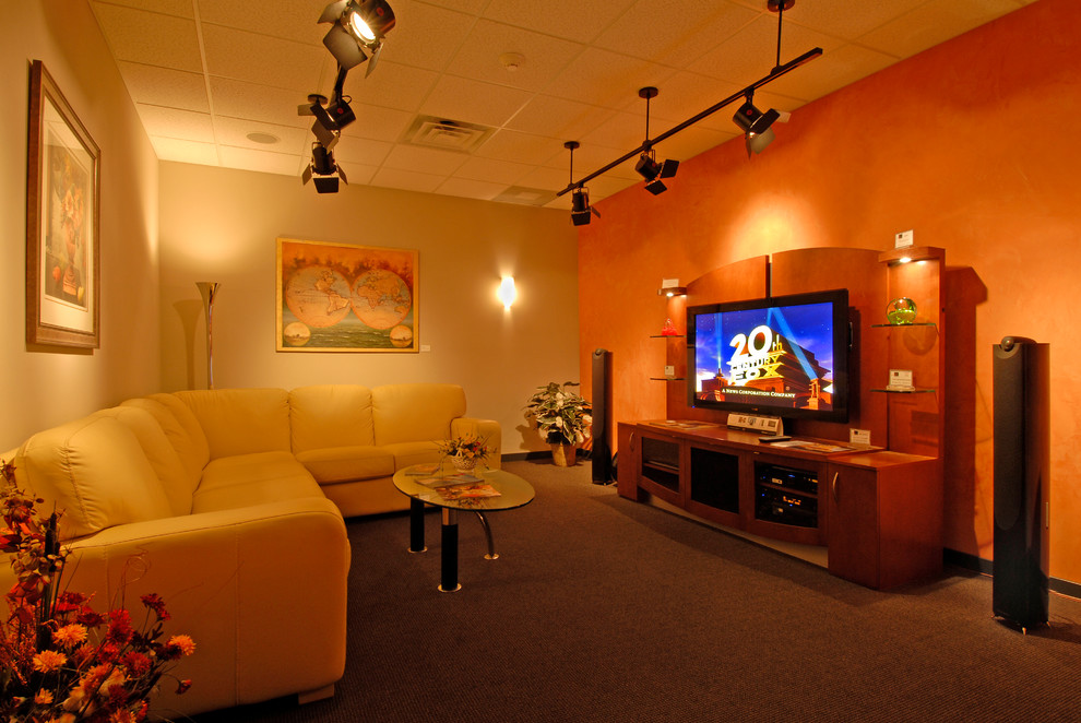 Mid-sized transitional enclosed home theatre in Philadelphia with beige walls, carpet and a wall-mounted tv.
