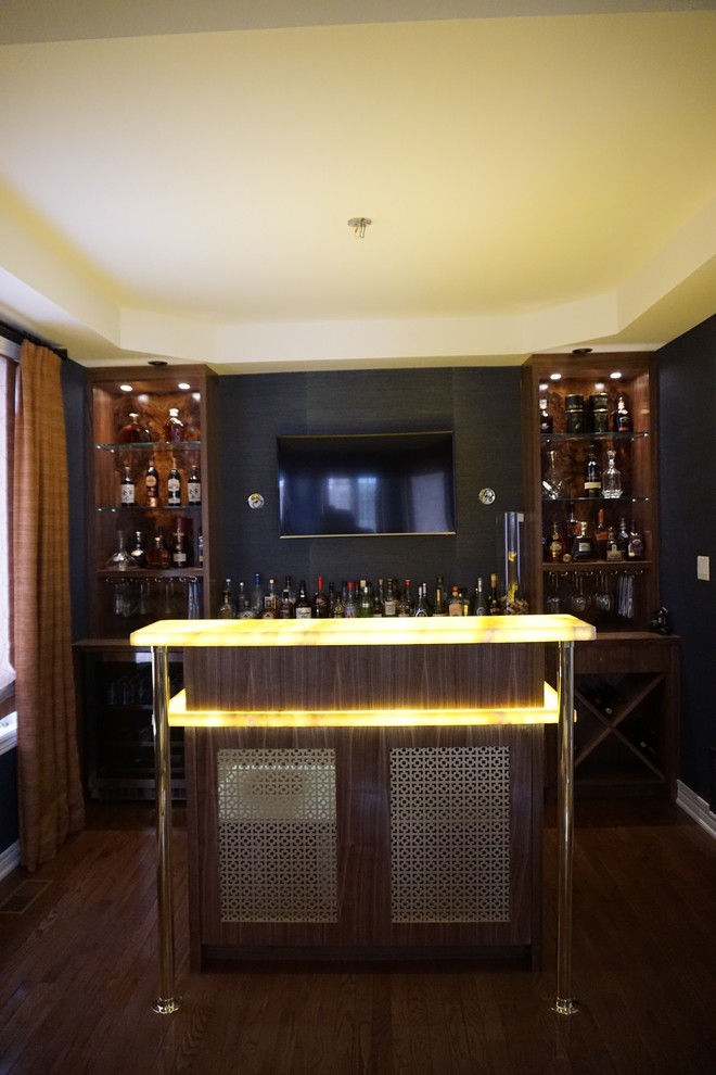 Photo of a mid-sized midcentury single-wall seated home bar in Toronto with a drop-in sink, flat-panel cabinets, medium wood cabinets, onyx benchtops, blue splashback and medium hardwood floors.