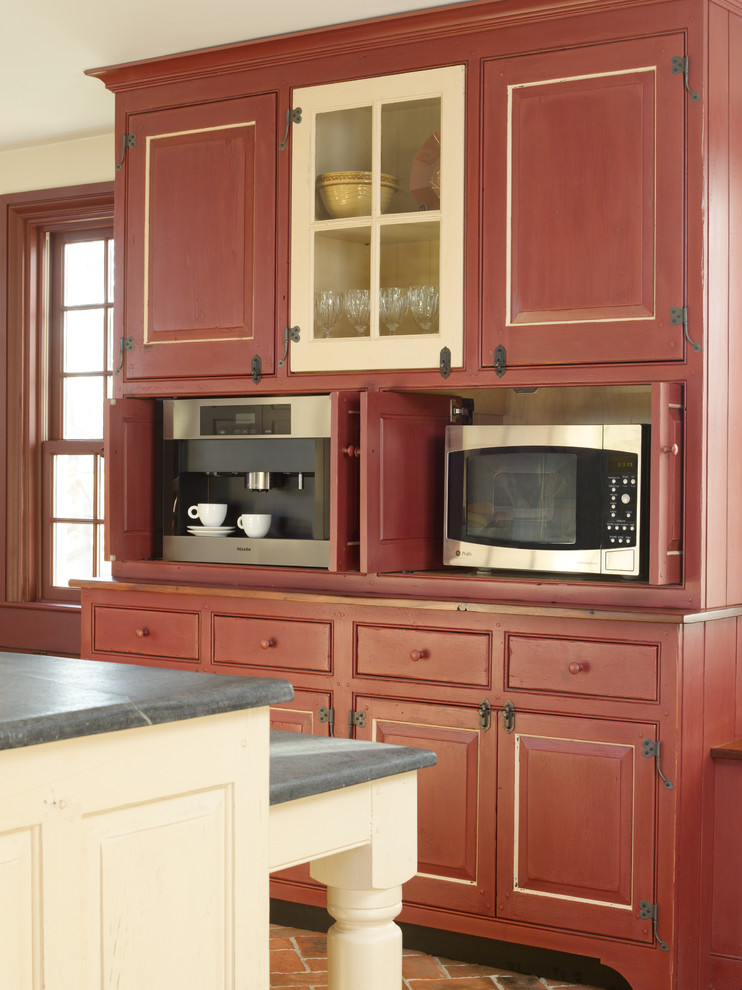 Mid-sized country single-wall eat-in kitchen in Philadelphia with a farmhouse sink, raised-panel cabinets, brick floors, with island, beige cabinets, concrete benchtops, panelled appliances, red floor and grey benchtop.