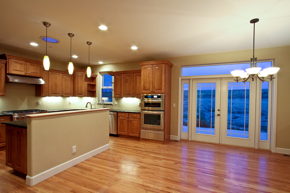 Inspiration for a transitional l-shaped eat-in kitchen remodel in Denver with an undermount sink, raised-panel cabinets, medium tone wood cabinets, granite countertops and stainless steel appliances