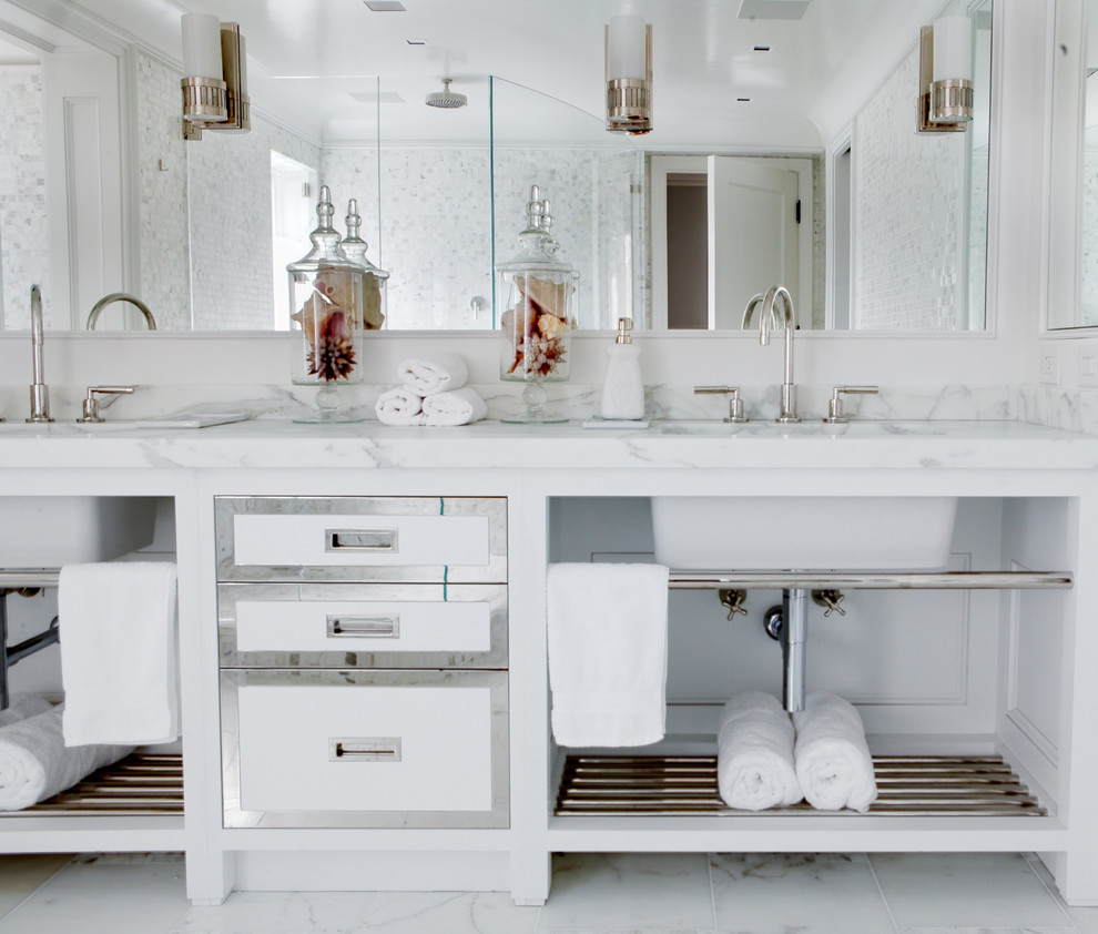 Photo of a large modern master bathroom in New York with shaker cabinets, white cabinets, a freestanding tub, a corner shower, white tile, mosaic tile, white walls, marble floors, an undermount sink, solid surface benchtops, white floor, a hinged shower door and white benchtops.