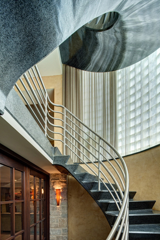 Contemporary curved staircase in Chicago with metal railing.