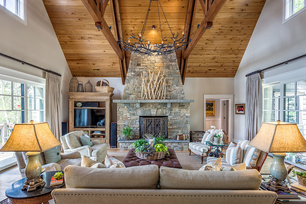 Inspiration for a large country enclosed family room in Other with white walls, a standard fireplace, a stone fireplace surround, no tv and medium hardwood floors.