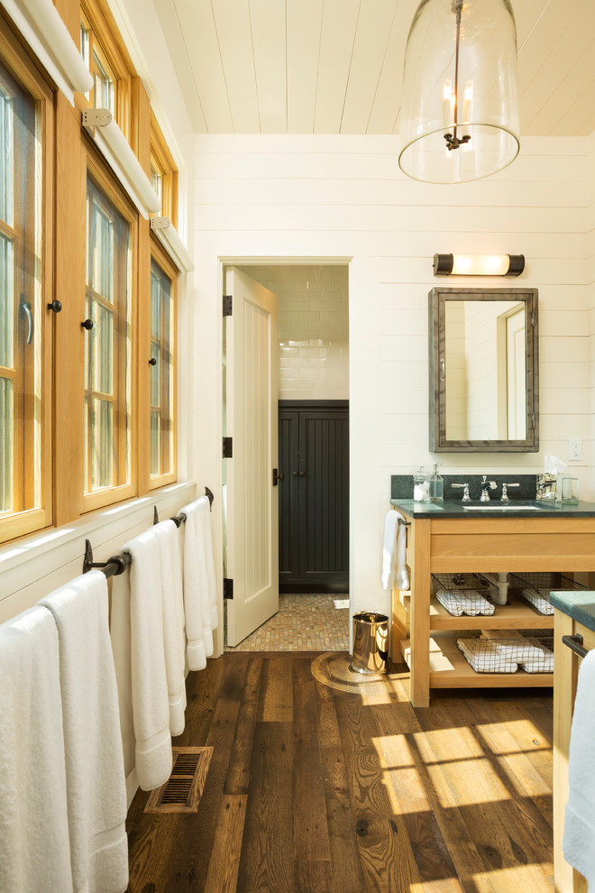 Photo of a country kids bathroom in Minneapolis with an undermount sink, medium wood cabinets, soapstone benchtops, white walls and dark hardwood floors.