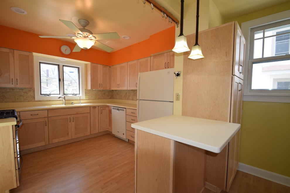 Kitchen - mid-sized transitional u-shaped light wood floor kitchen idea with an integrated sink, shaker cabinets, light wood cabinets, multicolored backsplash, stone tile backsplash, a peninsula and white countertops