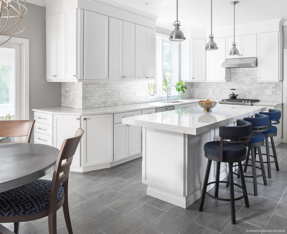Photo of a large transitional u-shaped open plan kitchen in Boston with an undermount sink, shaker cabinets, white cabinets, quartzite benchtops, white splashback, marble splashback, stainless steel appliances, slate floors, with island and grey floor.