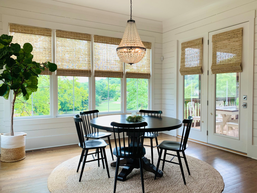 This is an example of a mid-sized arts and crafts dining room in Nashville with white walls, dark hardwood floors, no fireplace, brown floor and planked wall panelling.