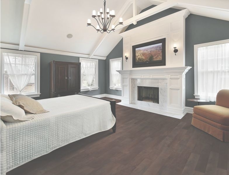 This is an example of a mid-sized transitional master bedroom in Orange County with blue walls, dark hardwood floors, a standard fireplace, a tile fireplace surround and brown floor.