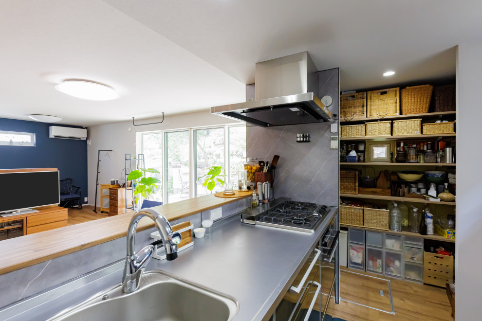 Foto di una cucina scandinava di medie dimensioni con ante in legno bruno, pavimento marrone e soffitto in carta da parati