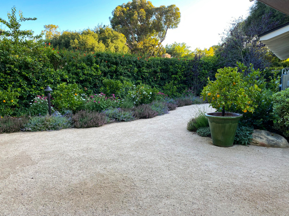 Idee per un giardino xeriscape country esposto in pieno sole dietro casa con graniglia di granito