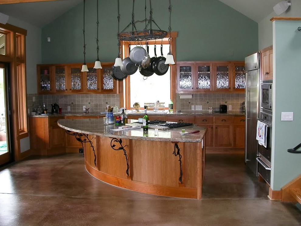 Eat-in kitchen - mid-sized transitional l-shaped concrete floor eat-in kitchen idea in Seattle with a drop-in sink, shaker cabinets, medium tone wood cabinets, granite countertops, gray backsplash, ceramic backsplash, stainless steel appliances and an island