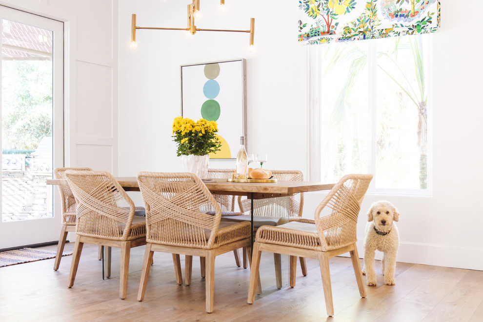 Inspiration for a beach style dining room in San Diego with white walls, light hardwood floors, no fireplace and beige floor.